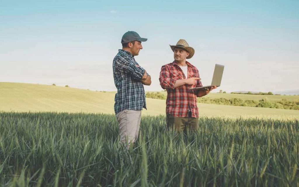 En la imagen se ve a una persona en el campo utilizando un sistema erp agricola