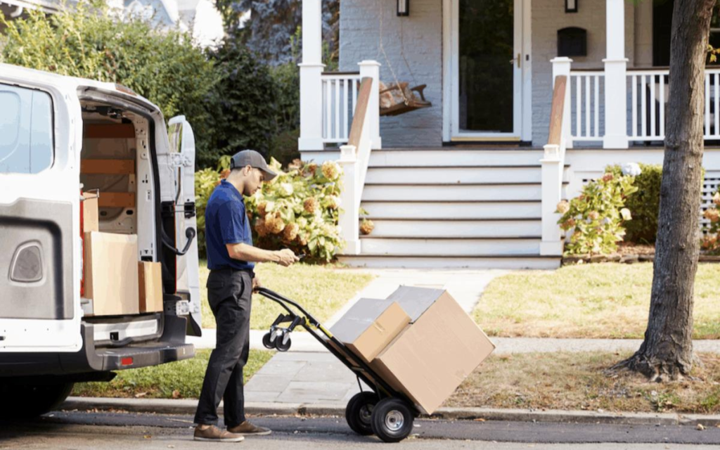 En la imagen se ve a una persona entregando un paquete en una casa como representación de last mile